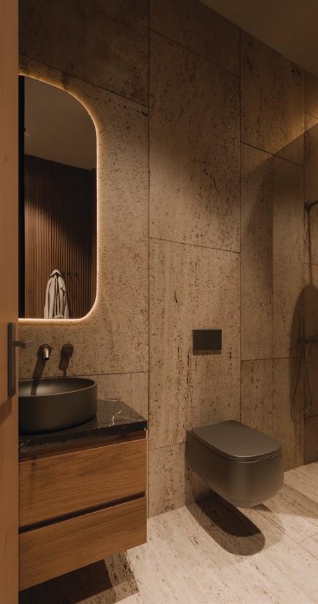 Bathroom with stone walls, wooden vanity, and wall-mounted toilet.