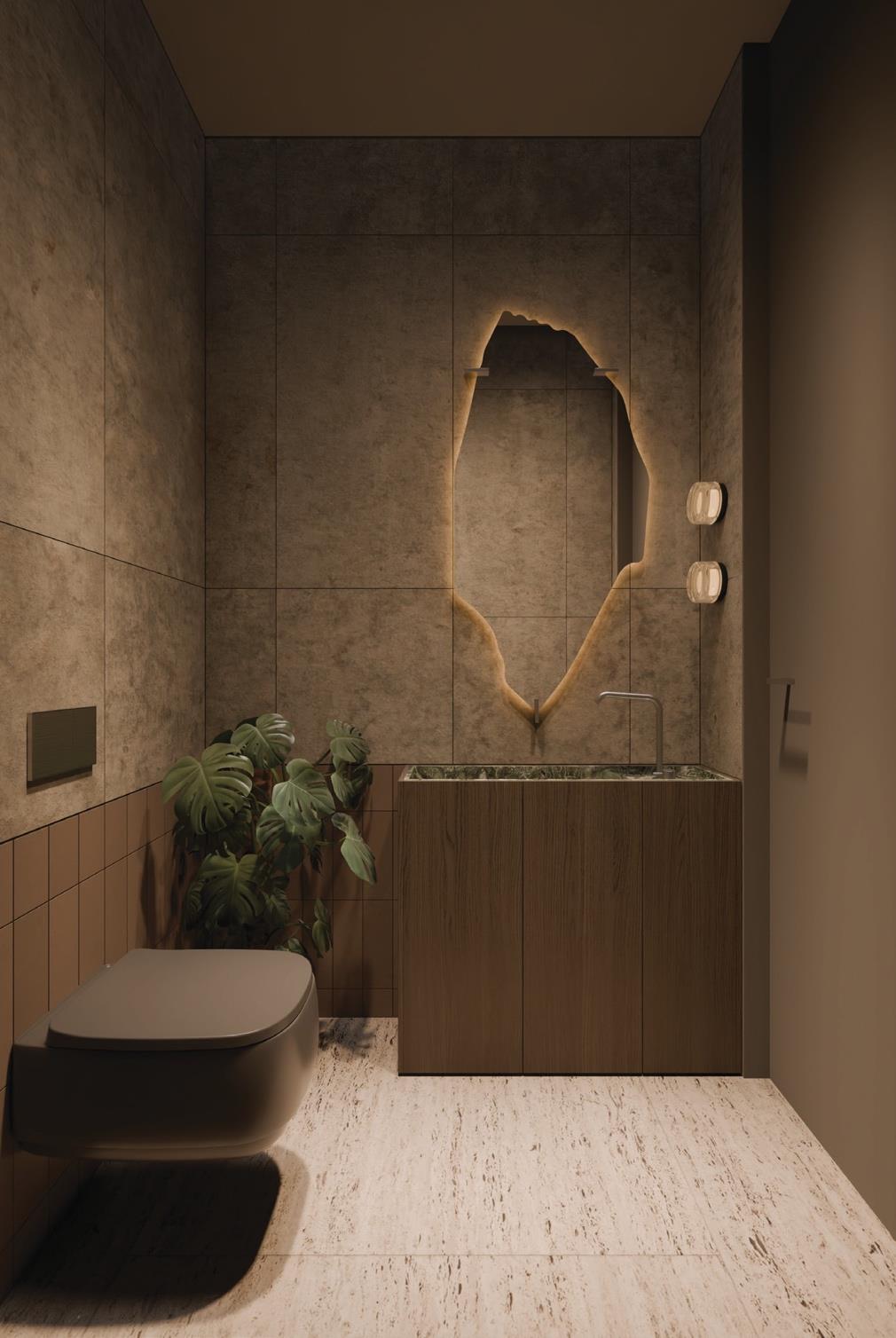 Modern bathroom with stone-tiled walls and backlit organic mirror.