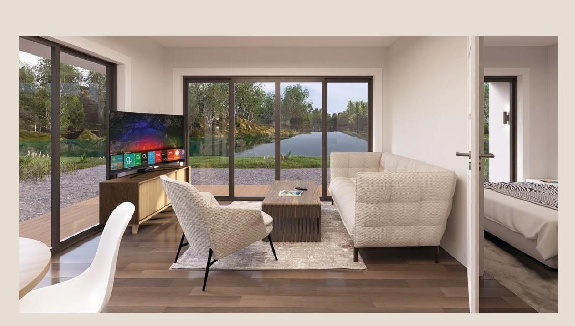 Open living area with lakeside view and adjacent bedroom.
